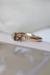 Guldring i rustikt design med oval, facetteret røgkvarts samt to små brillanter på hver sin side. Ringen er lavet i 14 karat guld og er massiv. All about ringene skal male verden i farver og symboliserer alt, der giver værdi for den, der bærer den. Mens de emmer af farver og liv, gemmer de på et tomt lærred, der venter på sin historie og betydning. Hvad skal de symbolisere for dig?