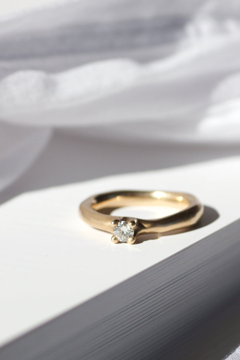 Simply ring i 14 karat guld, fin materet overflade samt én 0,20 ct. Top wesselton vvs brillant/diamant. ringen er det man kalder en solitairering og er fra vores ancient kollektion