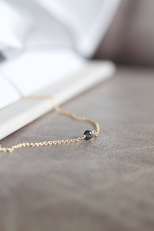 Alaia halskæde i 14 karat guld og enkel, sort diamant. Kæden er en rund ankerkæde.  POMPUS smykker er håndlavet og fra eget værksted her i Danmark