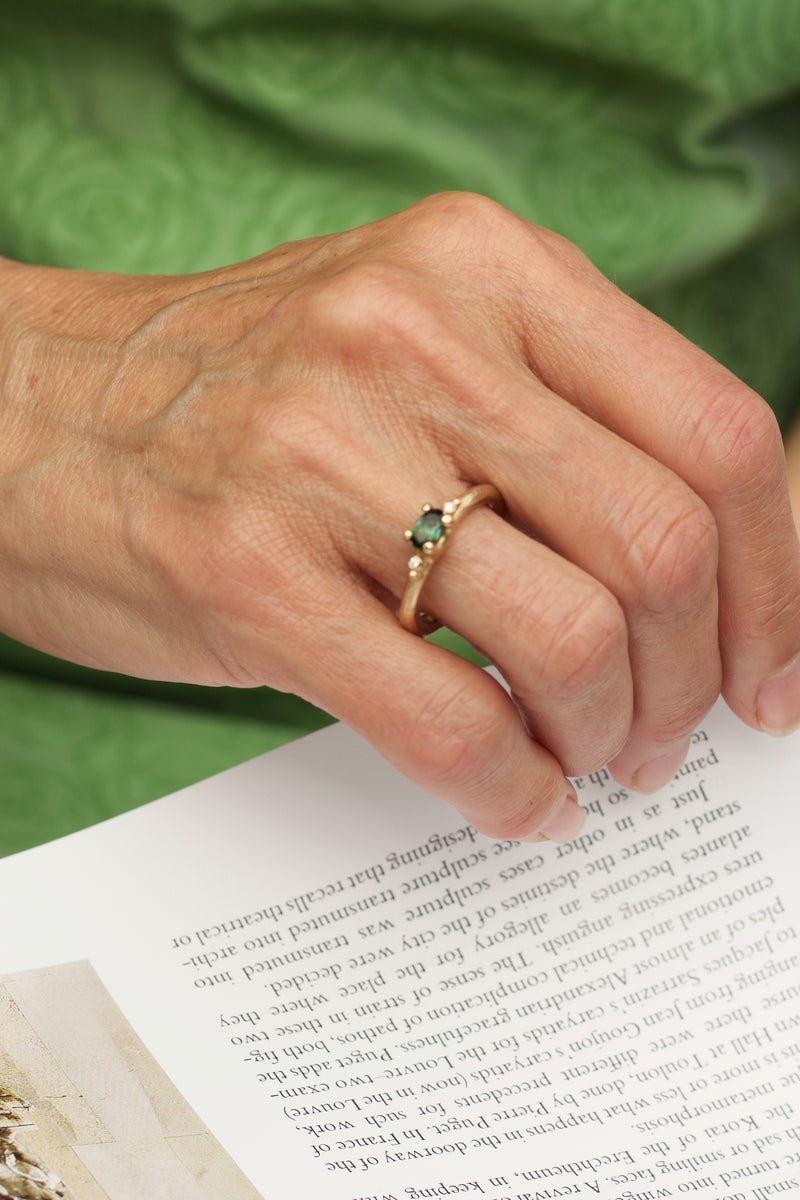Massiv 14 karat guldring i rustikt udtryk. Denne ring er med grøn turmalin, samt brillanter på siderne. All about ringene skal male verden i farver og symboliserer alt, der giver værdi for den, der bærer den. Mens de emmer af farver og liv, gemmer de på et tomt lærred, der venter på sin historie og betydning. Hvad skal de symbolisere for dig? 